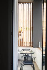 two chairs and a table in a room with a window at Santa Rosa Apartments in Kalamata