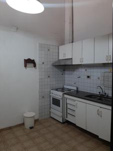 eine Küche mit weißen Schränken und einer Spüle und einem Herd in der Unterkunft Andino in La Cieneguita