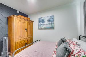Un dormitorio con una cama y un armario de madera. en Winnsboro Tiny House with Trails, Yard Games and More!, en Winnsboro
