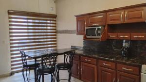 a kitchen with a table and chairs and a microwave at Cumbresuites in Monterrey