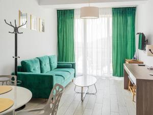 a living room with a green couch and a table at Bormio 27 Czarna Góra in Sienna