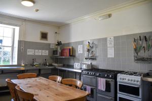 cocina con mesa y fogones horno superior en Ingleton Hostel, en Ingleton