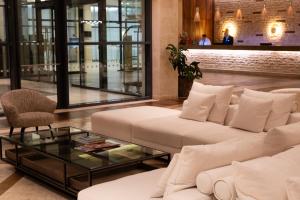 a living room with white couches and a glass table at Real Marina Hotel & Spa in Olhão