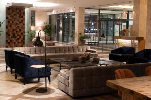 a lobby with couches and tables in a building at Real Marina Hotel & Spa in Olhão