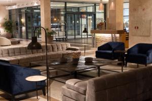 a lobby with couches and a table and chairs at Real Marina Hotel & Spa in Olhão
