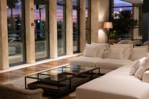 a living room with white couches and a glass table at Real Marina Hotel & Spa in Olhão