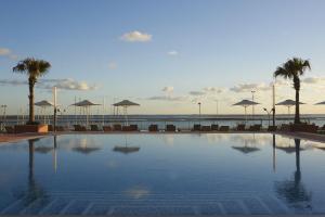 a large swimming pool with chairs and umbrellas at Real Marina Hotel & Spa in Olhão