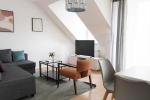 sala de estar con mesa, TV y sofá en URBAN FLATS Berlin, en Berlín