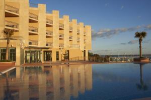 a large building with a swimming pool in front of it at Real Marina Hotel & Spa in Olhão