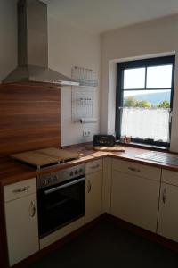 a kitchen with a stove top oven next to a window at Ferienwohnung Hof Lamberty in Niederprüm