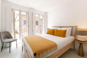 - une chambre avec un lit doté d'oreillers jaunes et d'une chaise dans l'établissement Modern 2-bed apartment with view to Clerigos Tower, à Porto
