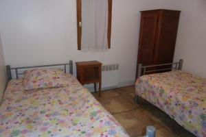 a bedroom with two beds and a table and a window at DOMAINE LE PLA de LIÉRE in Maury