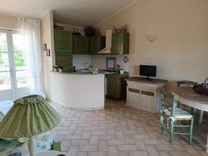 a kitchen with green cabinets and a table at Petit Plaisance in Capoliveri