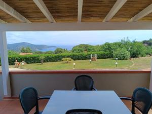 a dining room with a table and chairs and a view at Petit Plaisance in Capoliveri +8 photos