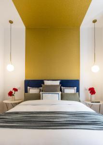 a bedroom with a large bed with a yellow wall at Gran Via by SkyKey in Madrid