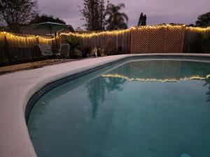 a swimming pool in a yard with lights on a fence at 3BR Oasis with Pool in Cocoa in Cocoa