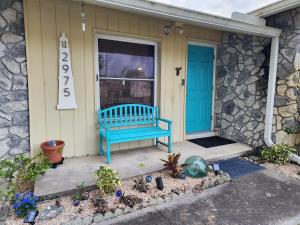 a blue bench sitting on the front porch of a house at 3BR Oasis with Pool in Cocoa in Cocoa