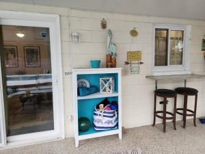 a white cabinet with two stools in front of a wall at 3BR Oasis with Pool in Cocoa in Cocoa