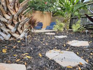 a garden with two blue benches and a fence at 3BR Oasis with Pool in Cocoa in Cocoa