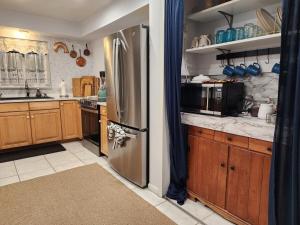 a kitchen with a stainless steel refrigerator and wooden cabinets at 3BR Oasis with Pool in Cocoa in Cocoa