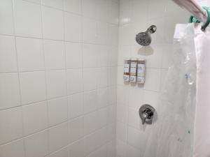 a white tiled shower with a silver shower head at 3BR Oasis with Pool in Cocoa in Cocoa