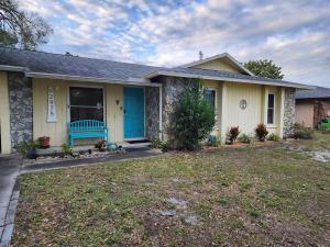 a house with a blue bench in the front yard at 3BR Oasis with Pool in Cocoa in Cocoa
