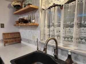 a kitchen with a sink and a window with curtains at 3BR Oasis with Pool in Cocoa in Cocoa