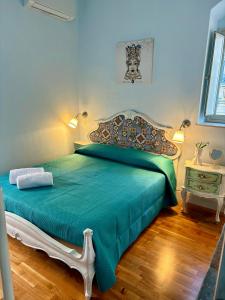 Un dormitorio con una cama con un edredón verde. en Casa A Mori, en Noto