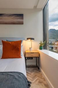 Luxurious Foreshore Getaway في كيب تاون: غرفة نوم مع سرير ومكتب مع نافذة