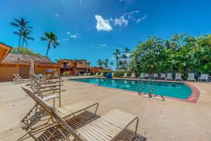 a swimming pool with lounge chairs and a resort at Puamana 30-2 in Lahaina