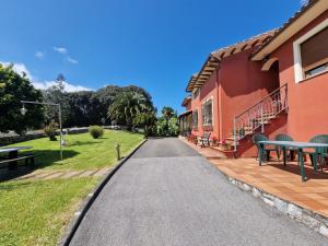 a road next to a red building with picnic tables at Casa de campo en Hontoria, Selnatur in Cardoso