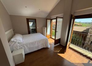 a bedroom with a white bed and a balcony at Villa Araceli in Suances