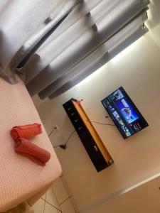 a room with a bed with a television and a tv at Flat Aconchegante in Goiânia