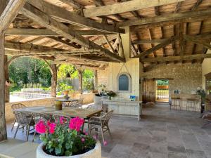 a large patio with a table and chairs at Maison d'hôtes De La Boissière in Andillac