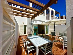 Un patio con una mesa y sillas y una sombrilla. en Casa Playa Paraiso, en Mojácar
