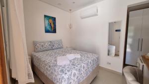a bedroom with a bed with two towels on it at Casa da Tieko in Ilhabela