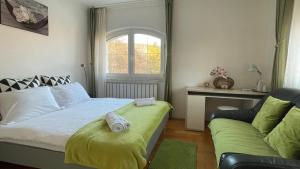 a bedroom with a bed and a window and a couch at Meszko Park House Budapest in Budapest