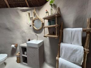 a bathroom with a sink and a toilet and towels at Art Village Tulum in Tulum