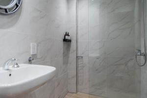 een witte badkamer met douche en wastafel bij Marfil Beautiful Apartment in Buenos Aires +46 foto's