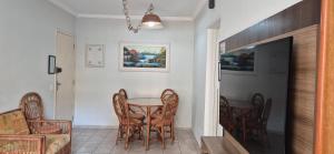 a dining room with a table and chairs at ESD01- Ar Condicionado 5min a pé da Praia da Enseada, Apartamento in Guarujá +14 photos