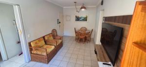 a living room with chairs and a dining room at ESD01- Ar Condicionado 5min a pé da Praia da Enseada, Apartamento in Guarujá