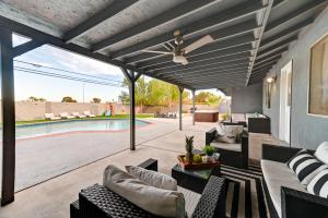 a patio with a ceiling fan and a swimming pool at Vila Paradise-Luxury 5BD Retreat Perfect for Groups & Families in Las Vegas