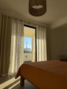 a bedroom with a bed and a large window at Equinox Appartment in La Gaulette