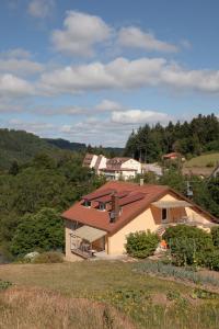 une maison avec un toit rouge sur une colline dans l'établissement Gites de la Cascade, à Le Tholy