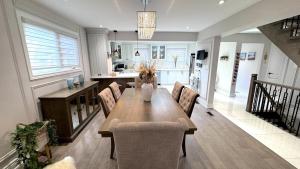 a kitchen and dining room with a wooden table and chairs at Luxury Modern Retreat, Sauna, Theatre, Pool Table in Mississauga