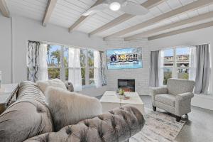 a living room with a couch and a chair at Gulf Access, Dock, Heated Pool, Across from the Beach - Sea-cluded Bungalow -Roelens in Fort Myers Beach