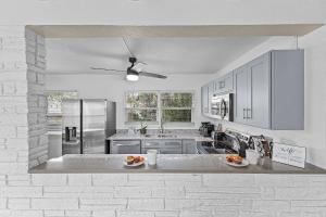 a kitchen with white cabinets and a counter top at Gulf Access, Dock, Heated Pool, Across from the Beach - Sea-cluded Bungalow -Roelens in Fort Myers Beach