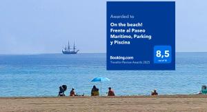 grupa ludzi na plaży ze statkiem w oceanie w obiekcie On the beach! Frente al Paseo Marítimo, Parking y Piscina w Maladze