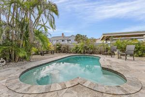 a swimming pool in the middle of a yard at Gulf Access, Dock, Heated Pool, Across from the Beach - Sea-cluded Bungalow -Roelens in Fort Myers Beach