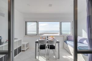 a dining room with a table and chairs and a bed at Horizonte Azul , Frente mar & Piscina in Costa da Caparica